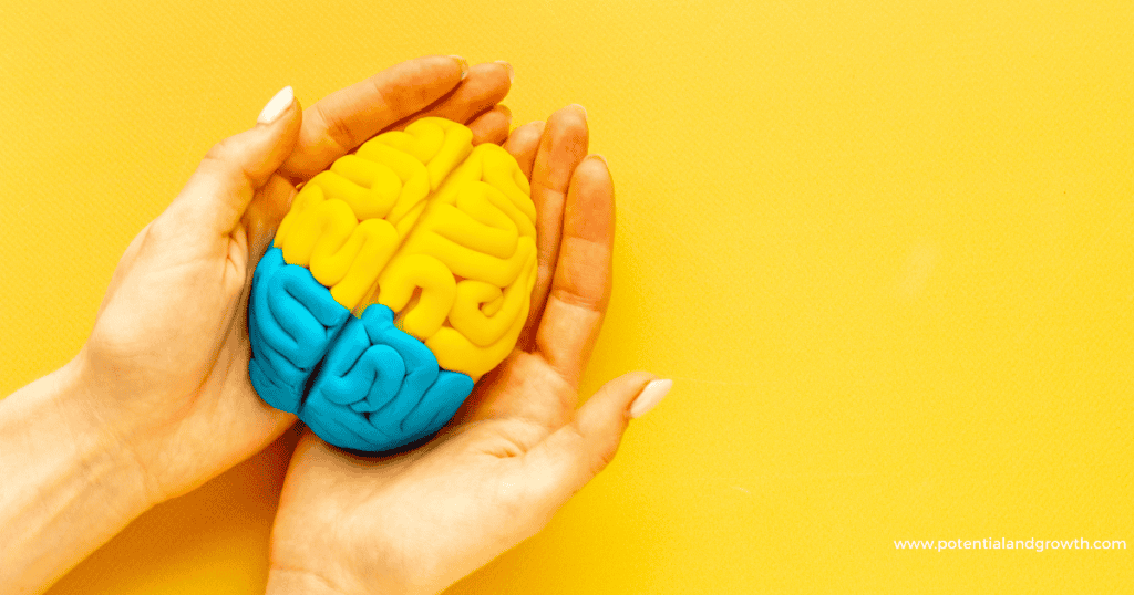 lady holding a yellow and blue colored toy brain with a yellow background 