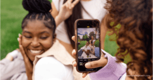 Teen girls taking pictures on smartphone and posing (smiling)